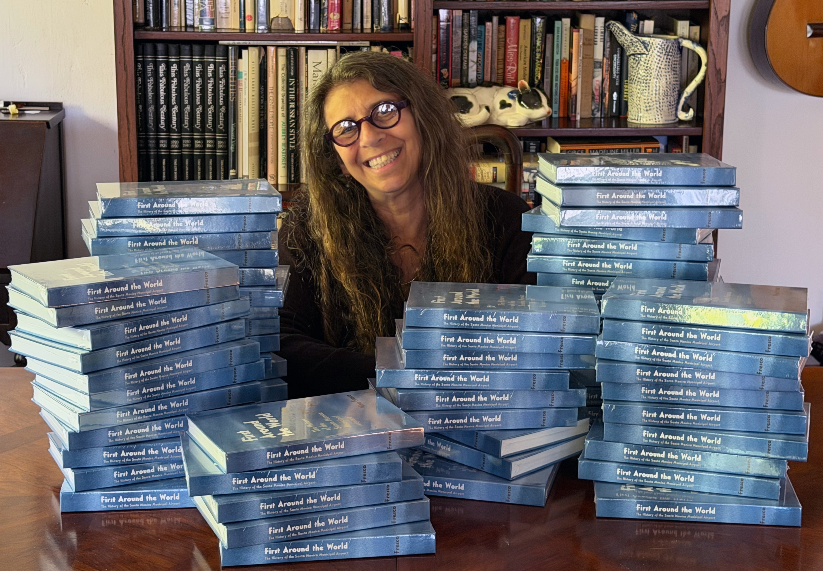 Author with piles of books.